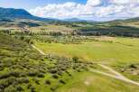 Discover the tranquility of this stunning property, featuring expansive green pastures and rolling hills.
