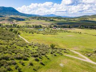 Discover the tranquility of this stunning property, featuring expansive green pastures and rolling hills.