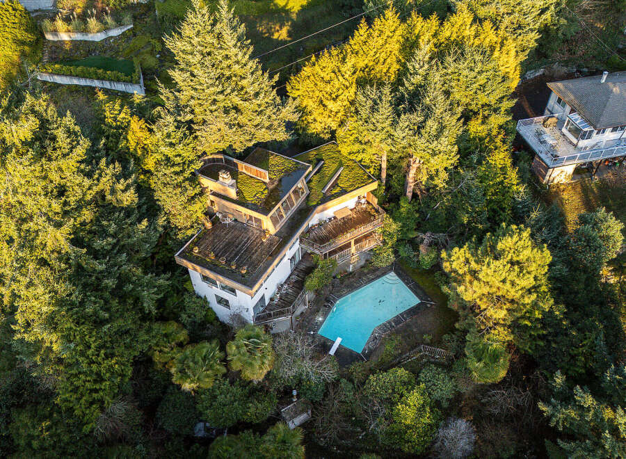 Nestled amidst lush greenery, this stunning property boasts a unique architectural design with a green roof, offering a harmonious blend of nature and modern living.