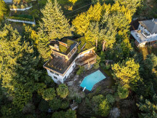Nestled amidst lush greenery, this stunning property boasts a unique architectural design with a green roof, offering a harmonious blend of nature and modern living.