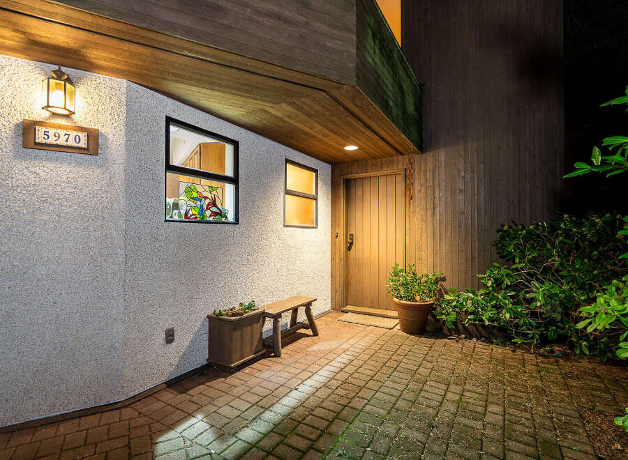 Welcome to this charming property! This home features a beautifully designed entrance with a wooden door and a brick patio.