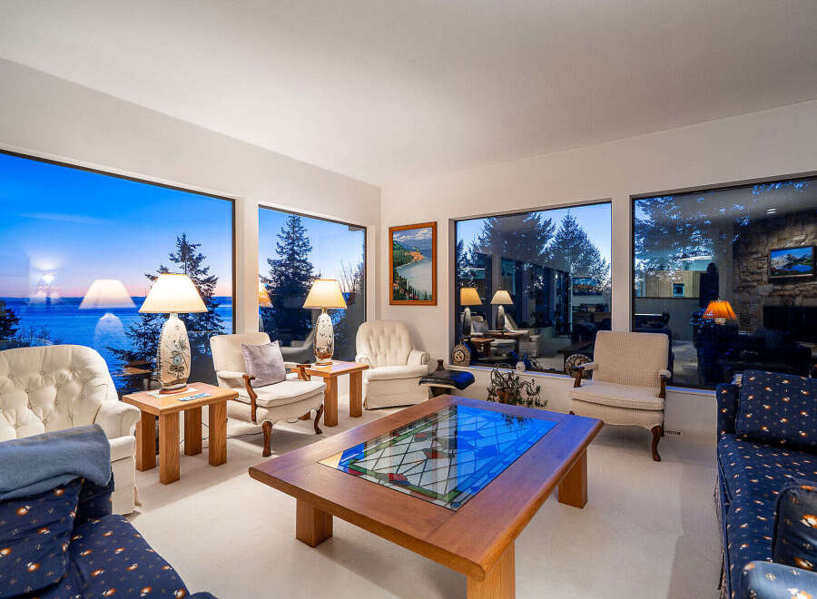 Experience breathtaking views from this stunning living room, featuring expansive windows that frame the serene landscape.