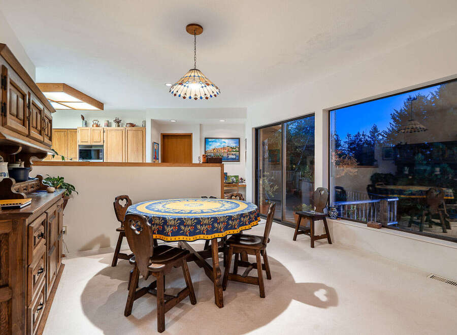 This charming dining room features a round wooden table with seating for four, perfect for intimate gatherings.