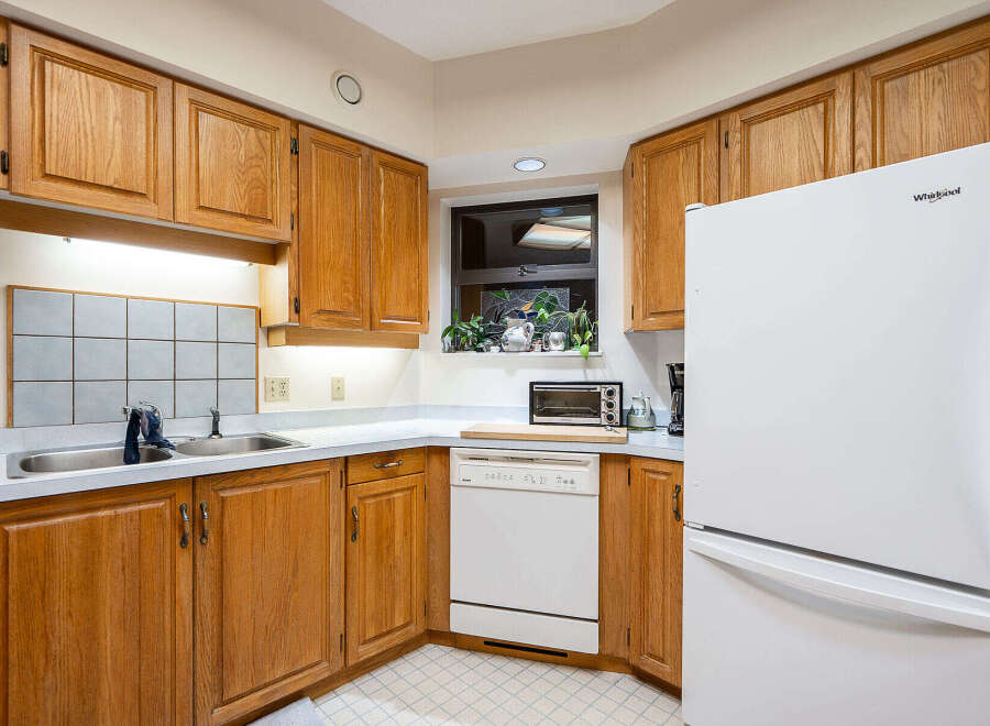 Step into this inviting kitchen, featuring warm wooden cabinetry and ample counter space.