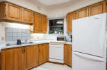 Step into this inviting kitchen, featuring warm wooden cabinetry and ample counter space.
