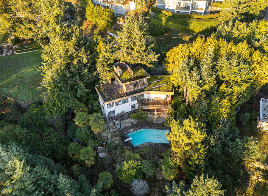 Nestled amidst lush greenery, this stunning property boasts a unique architectural design with a green roof.