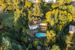 Nestled amidst lush greenery, this stunning property boasts a unique architectural design with a green roof.