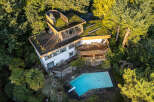 This stunning property boasts a unique architectural design, seamlessly blending with its lush, natural surroundings.
