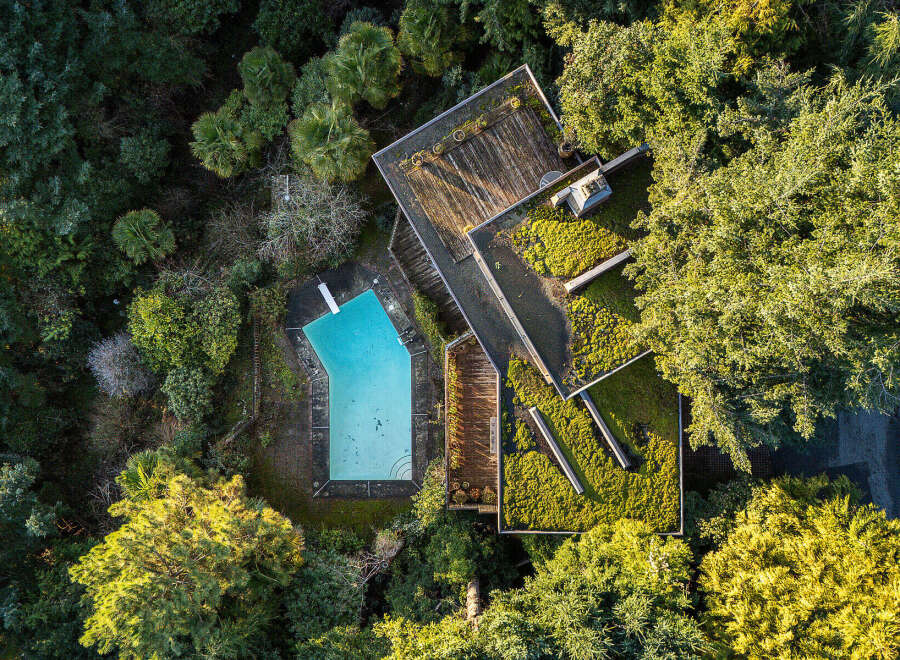 Discover a unique property nestled in a lush, green landscape, featuring a stunning architectural design.