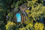 Discover a unique property nestled in a lush, green landscape, featuring a stunning architectural design.