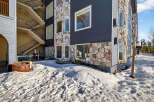 This stunning property boasts a unique architectural design with a combination of stone and dark siding, creating a modern yet rustic aesthetic.