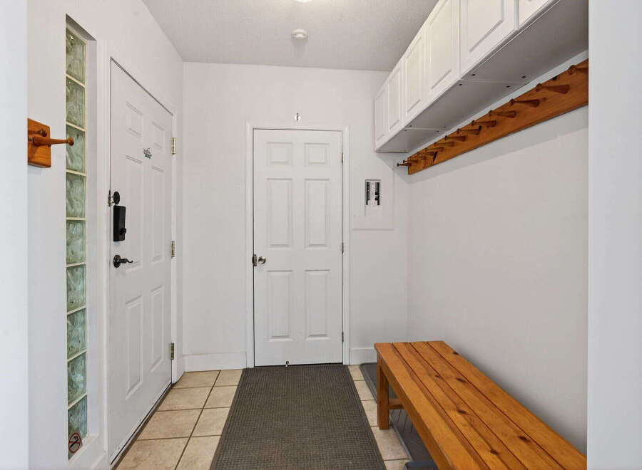Step into this inviting entryway, featuring a stylish bench and ample storage.