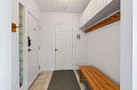 Step into this inviting entryway, featuring a stylish bench and ample storage.