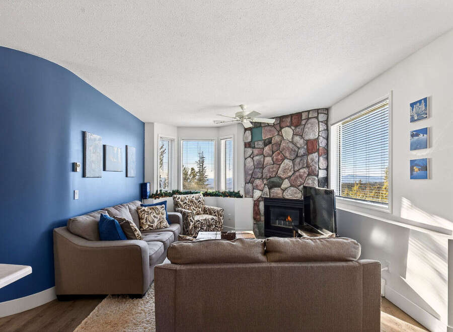 Step into this inviting living space, featuring a cozy fireplace and a stylish stone accent wall.