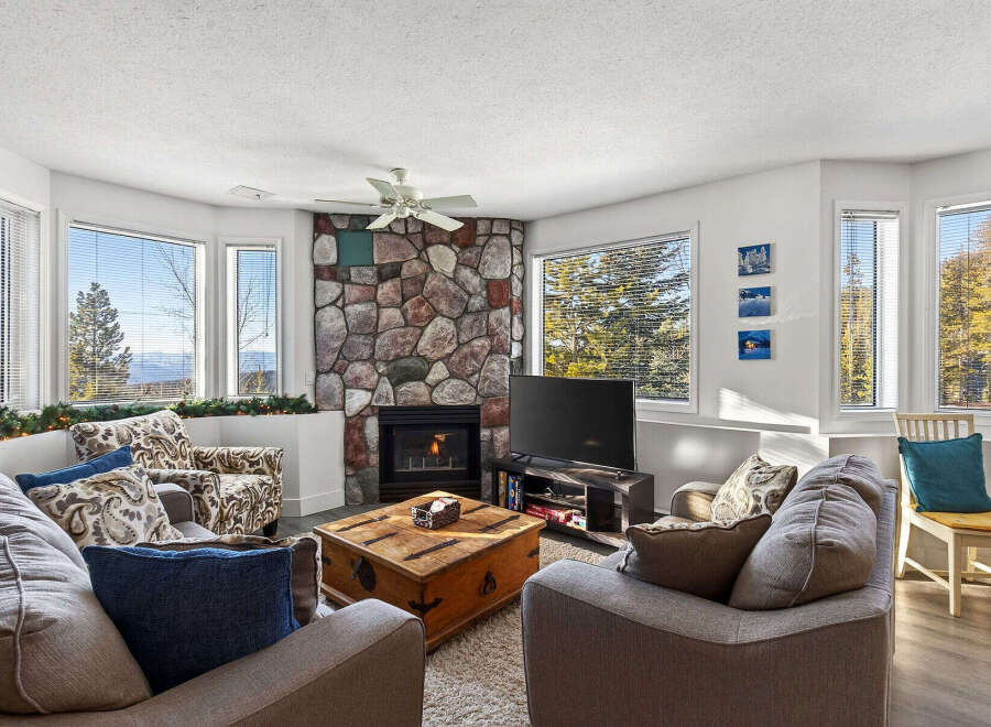 This stunning living room boasts a cozy fireplace and ample natural light, perfect for relaxing or entertaining.