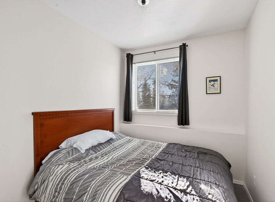This cozy bedroom features a comfortable bed with a stylish comforter, perfect for a relaxing night's sleep.