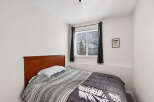 This cozy bedroom features a comfortable bed with a stylish comforter, perfect for a relaxing night's sleep.