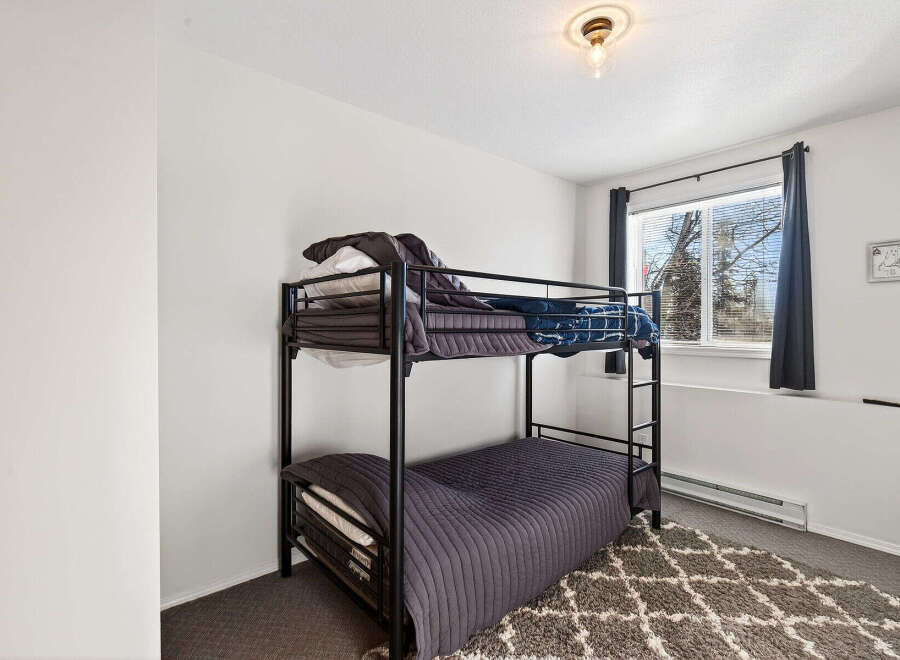 This cozy bedroom features a stylish bunk bed, perfect for maximizing space.