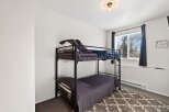 This cozy bedroom features a stylish bunk bed, perfect for maximizing space.