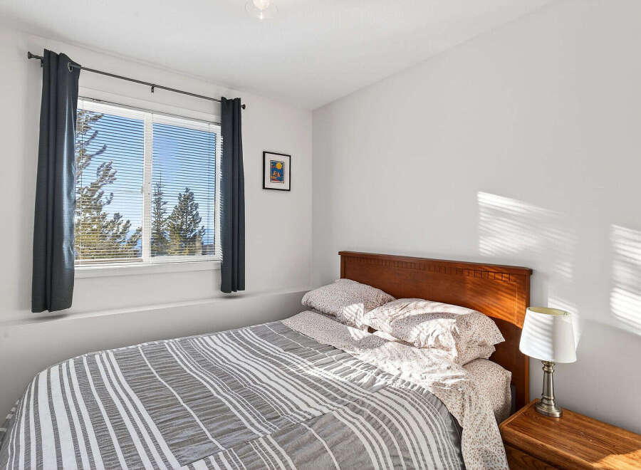 This cozy bedroom features a comfortable bed with a stylish striped comforter.