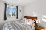 This cozy bedroom features a comfortable bed with a stylish striped comforter.
