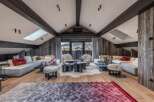 Experience luxury living in this stunning property, featuring a spacious living area with a vaulted ceiling and exposed beams.