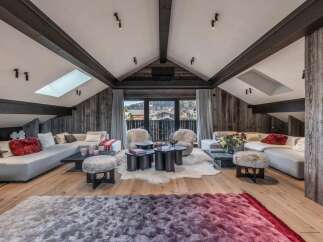 Experience luxury living in this stunning property, featuring a spacious living area with a vaulted ceiling and exposed beams.