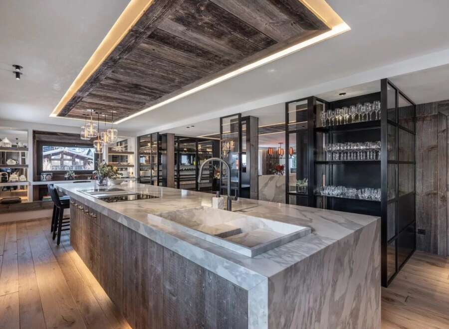 Experience luxury living in this stunning kitchen, featuring a spacious marble countertop island and elegant wooden accents.