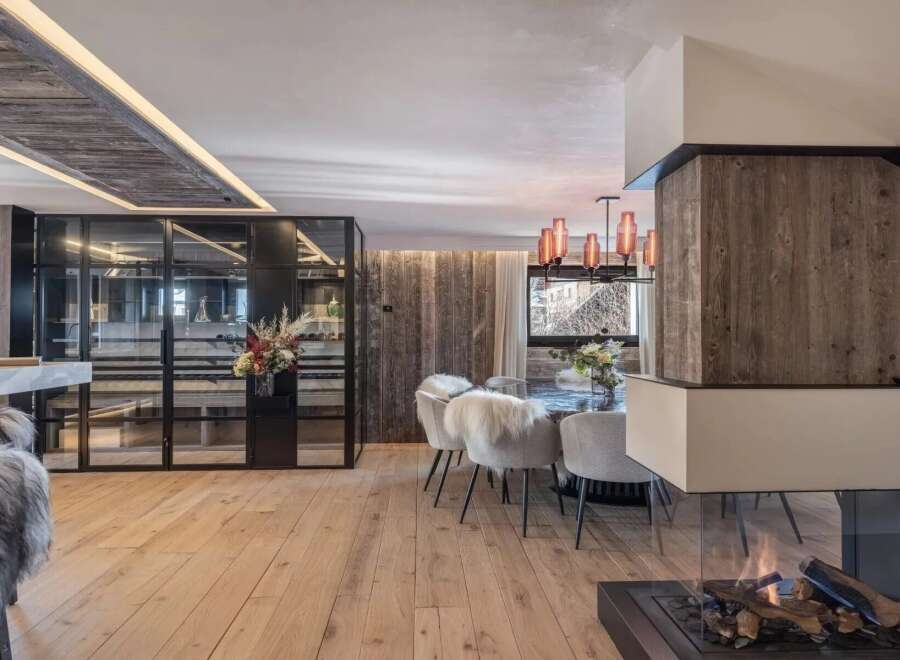 Experience luxury living in this stunning property, featuring a modern interior design with a cozy fireplace and elegant dining area.