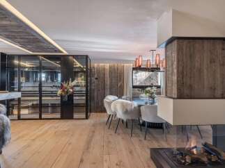 Experience luxury living in this stunning property, featuring a modern interior design with a cozy fireplace and elegant dining area.