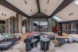 Experience luxury living in this stunning property, featuring a beautifully designed living room with rustic wooden accents and a cozy ambiance.