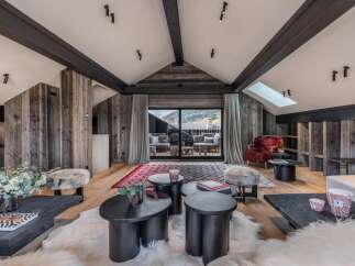 Experience luxury living in this stunning property, featuring a beautifully designed living room with rustic wooden accents and a cozy ambiance.