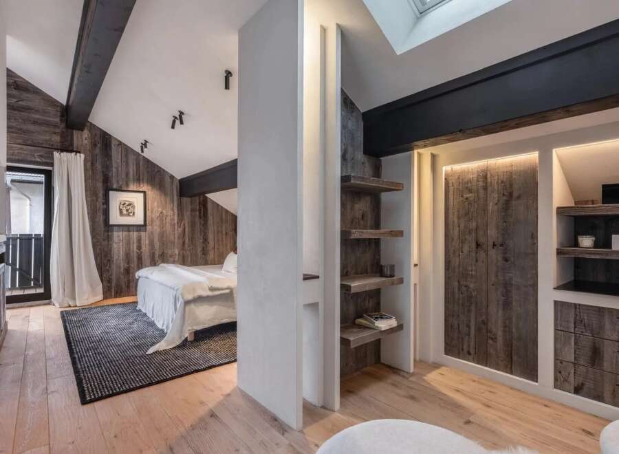 This stunning bedroom boasts a rustic charm with its wooden paneling and exposed beams, creating a warm and inviting atmosphere.