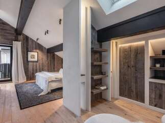 This stunning bedroom boasts a rustic charm with its wooden paneling and exposed beams, creating a warm and inviting atmosphere.