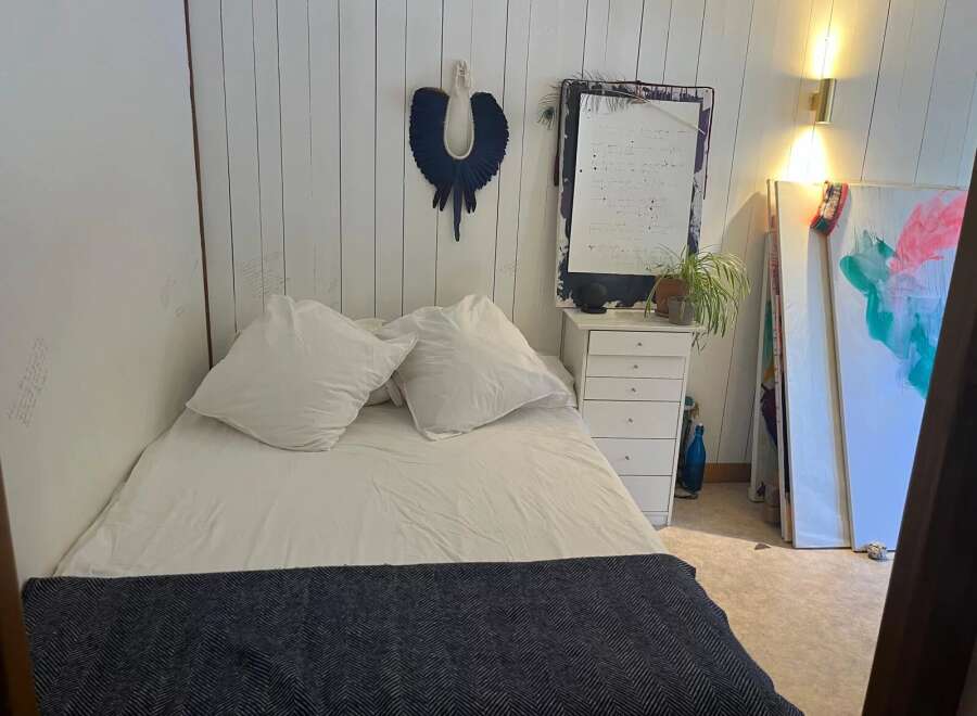 This cozy bedroom features a comfortable bed with soft pillows and a stylish navy throw.