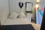 This cozy bedroom features a comfortable bed with soft pillows and a stylish navy throw.