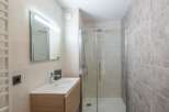 Step into this modern bathroom, featuring a sleek glass shower enclosure and stylish vanity.