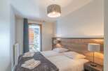 This cozy bedroom offers a serene retreat with its inviting ambiance and stylish decor.