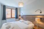 This cozy bedroom features a comfortable bed with crisp white linens and plush pillows, perfect for a relaxing stay.