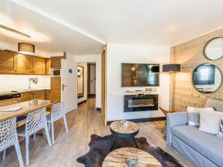 Discover the charm of this beautifully designed property, featuring a cozy living area with a modern fireplace and a stylish dining space.