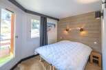 This cozy bedroom features a comfortable bed with a plush white comforter, perfect for a relaxing stay.