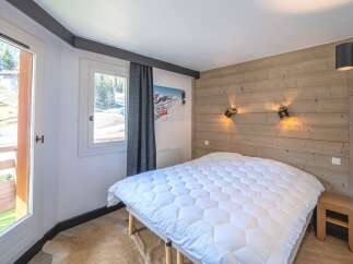 This cozy bedroom features a comfortable bed with a plush white comforter, perfect for a relaxing stay.
