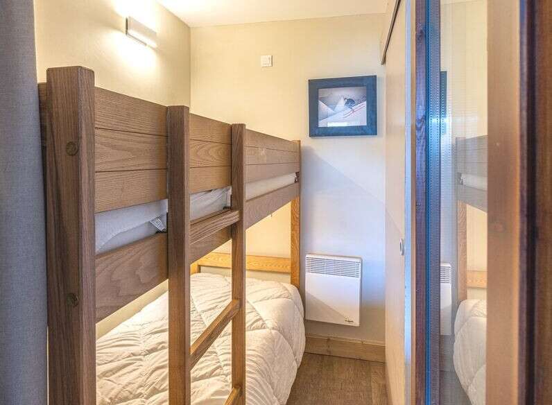 This cozy bedroom features a charming bunk bed, perfect for accommodating guests or family members.