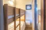 This cozy bedroom features a charming bunk bed, perfect for accommodating guests or family members.