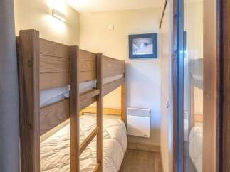 This cozy bedroom features a charming bunk bed, perfect for accommodating guests or family members.