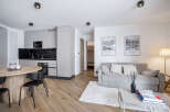 Discover modern living in this stylish apartment, featuring a sleek kitchen with integrated appliances and a cozy living area.