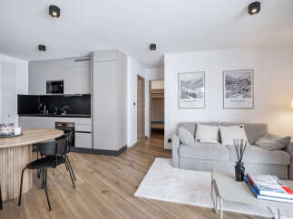 Discover modern living in this stylish apartment, featuring a sleek kitchen with integrated appliances and a cozy living area.