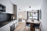Experience modern living in this stylish apartment, featuring a sleek kitchen with contemporary appliances and ample counter space.