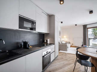 Discover modern living in this stylish apartment featuring a sleek kitchen with stainless steel appliances and ample storage.