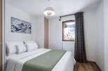 This cozy bedroom offers a serene retreat with stunning mountain views visible through the window.